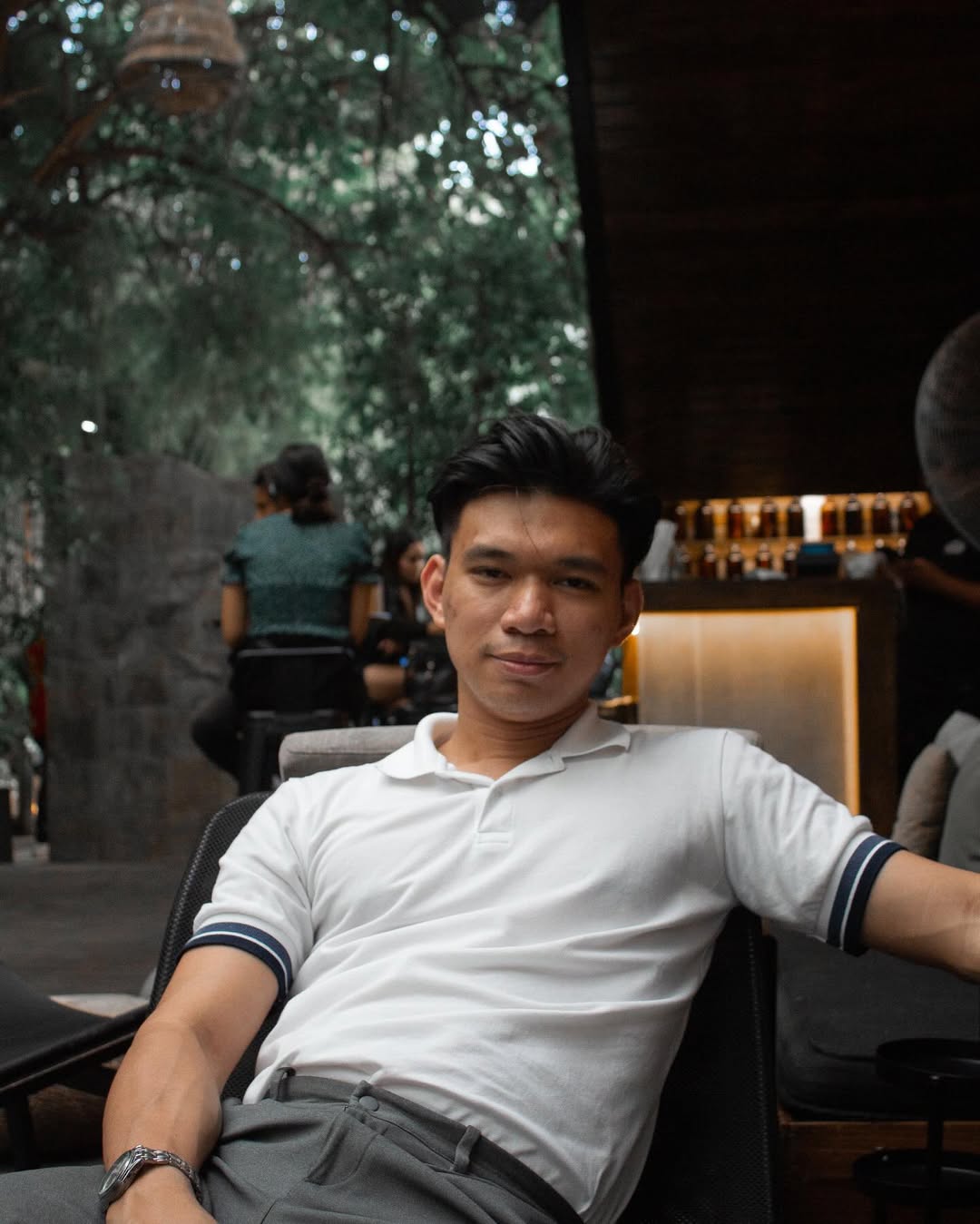 Elcid Villegas seated at a café, smiling toward the camera.
